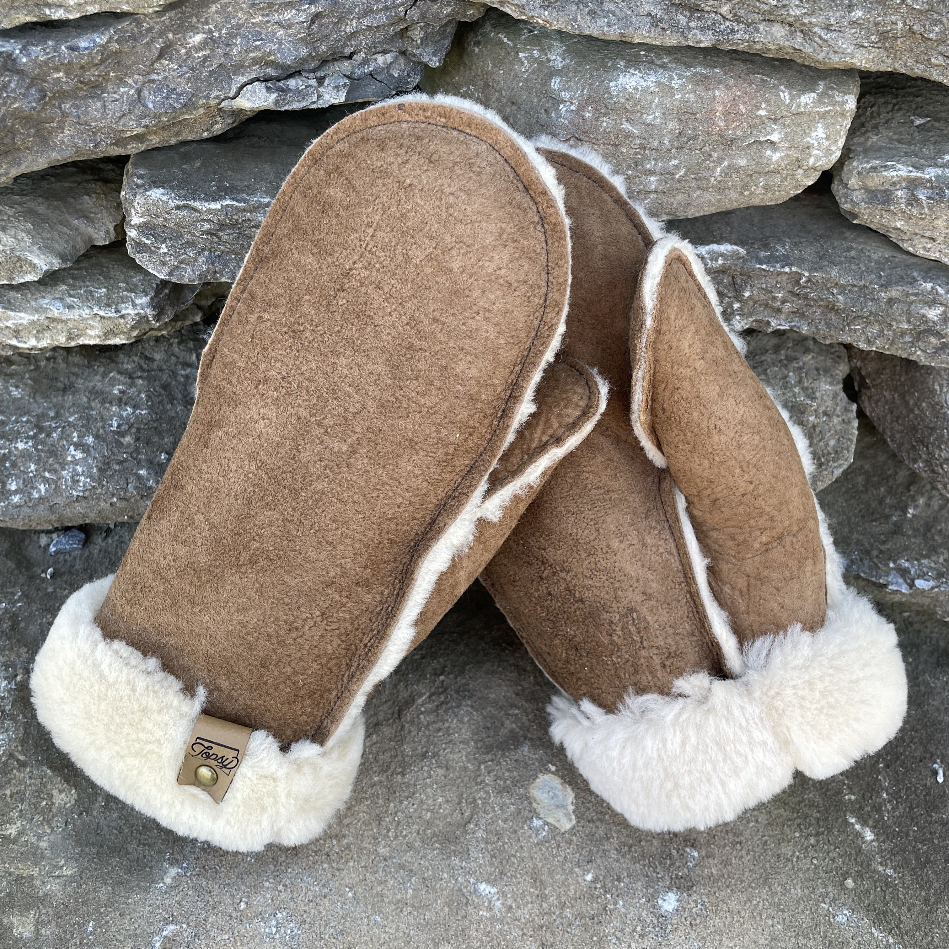 Topsy Farms' Canadian sheepskin mittens on a rock wall