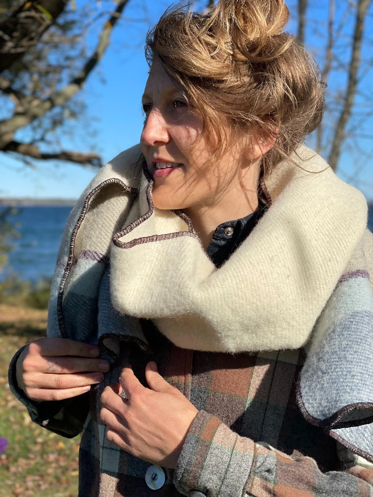 Blonde woman by the lake wearing Topsy Farms' unique Shoreline blanket scarf