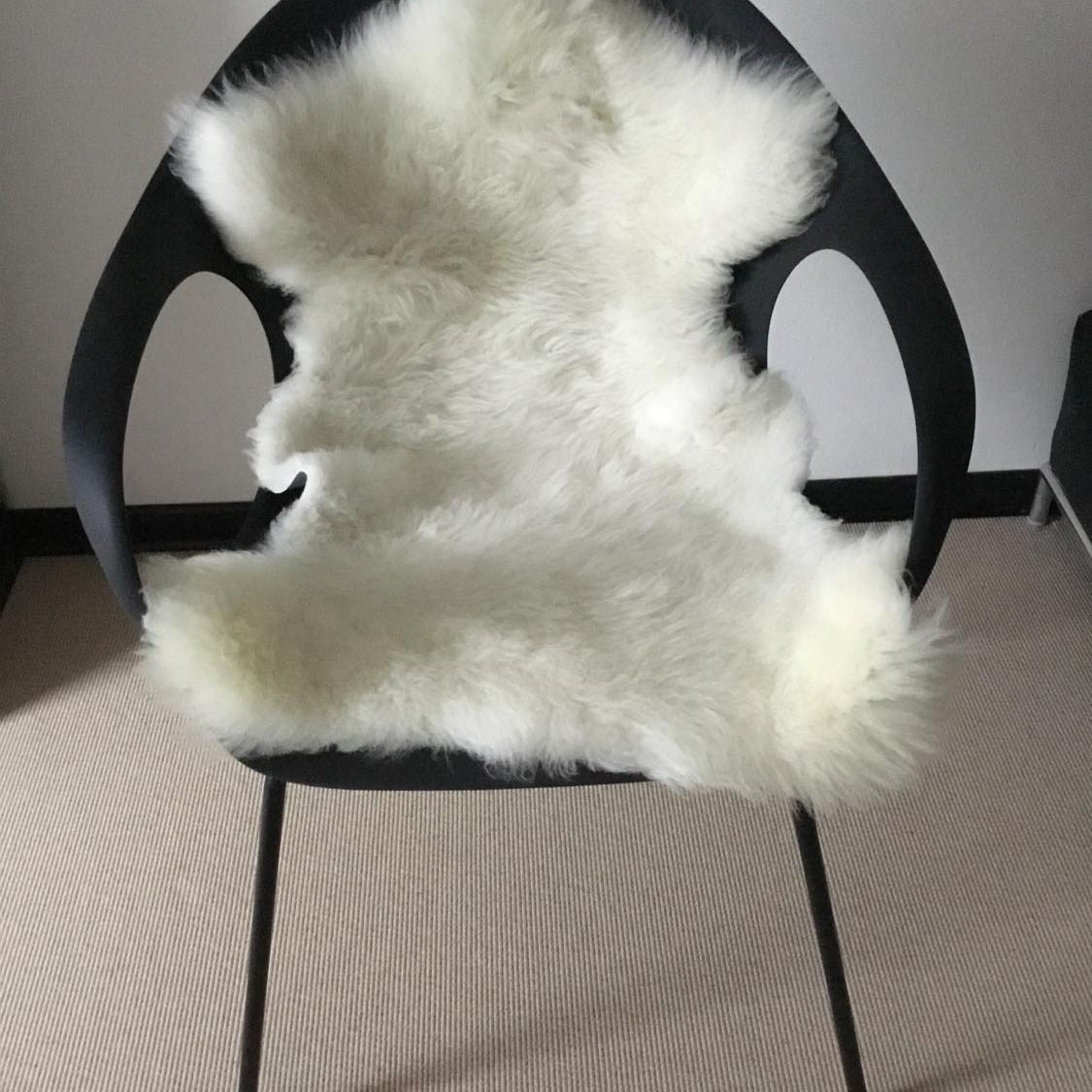 Topsy Farms' white lambskin on a black modern arm chair