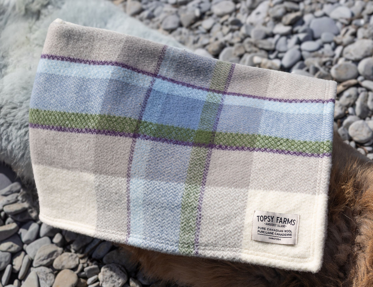 Topsy Farms' Shoreline Canadian wool throw on a rocky beach
