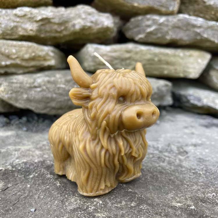 Topsy Farms' handmade beeswax candle in the shape of a highland cow
