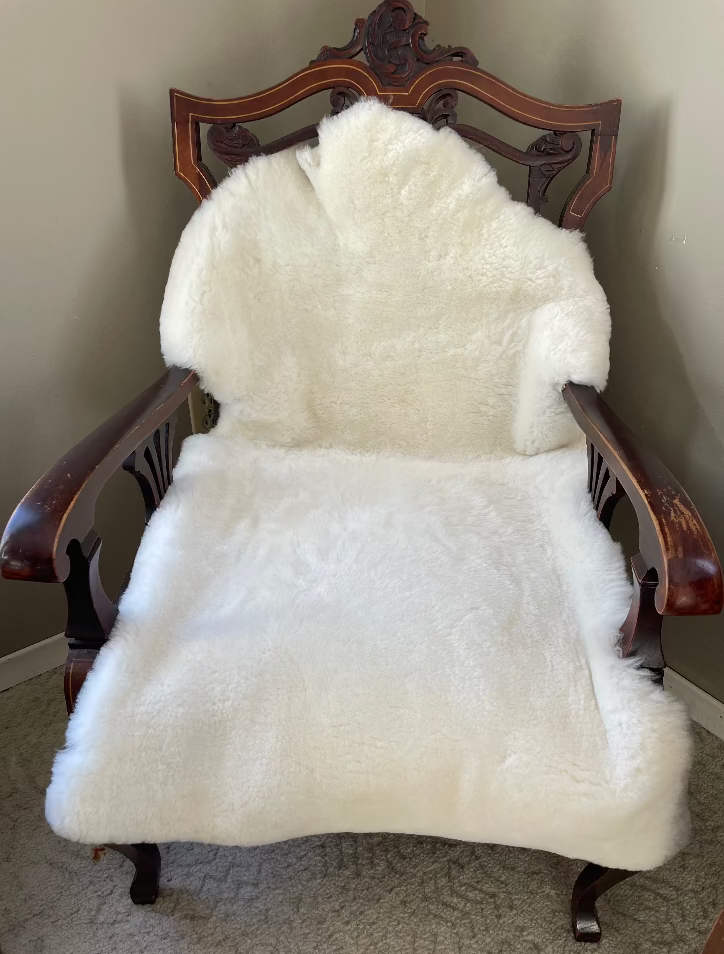 Topsy Farms' white sheepskin on a wooden armchair
