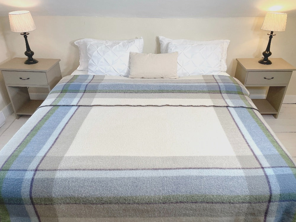 Topsy Farms' Shoreline wool blanket on a king size bed