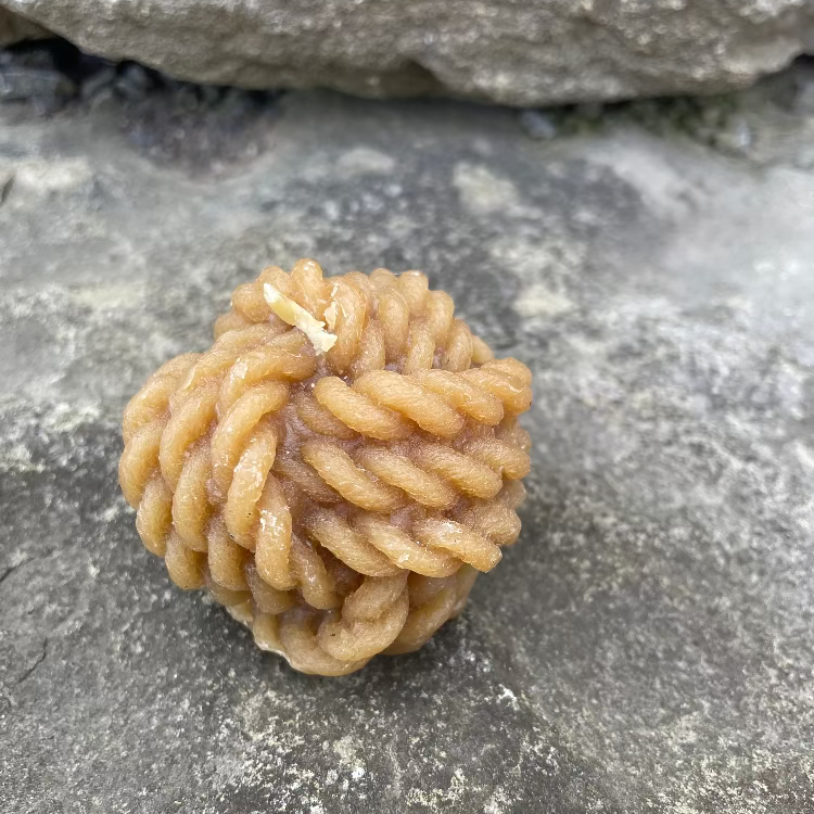 Topsy Farms' handmade beeswax candle in the shape of knotted rope