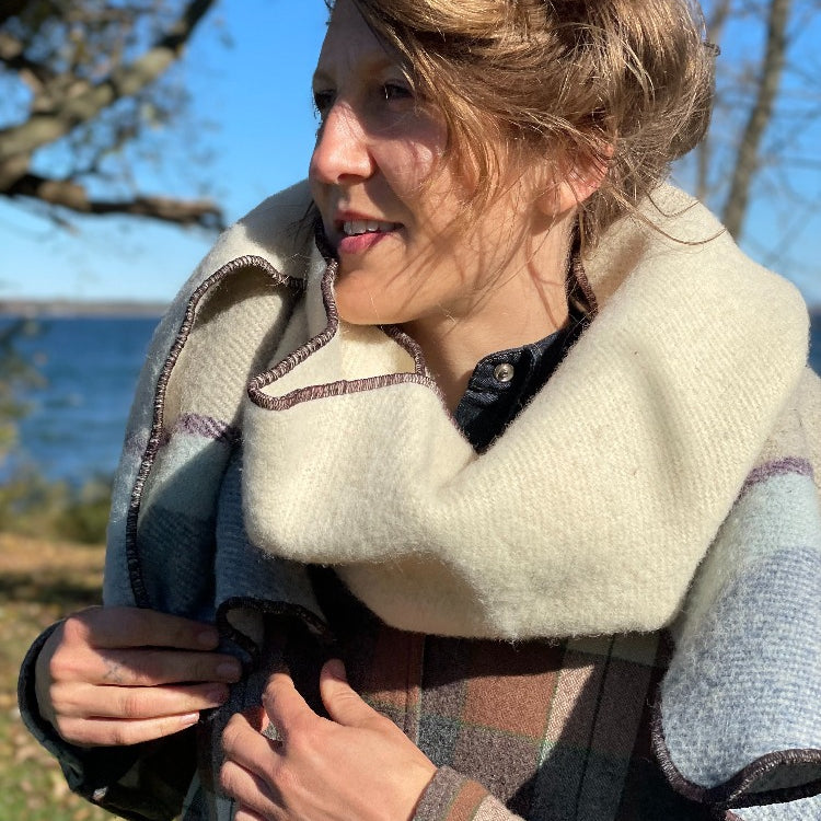 Blonde woman by the lake wearing Topsy Farms' unique Shoreline blanket scarf 