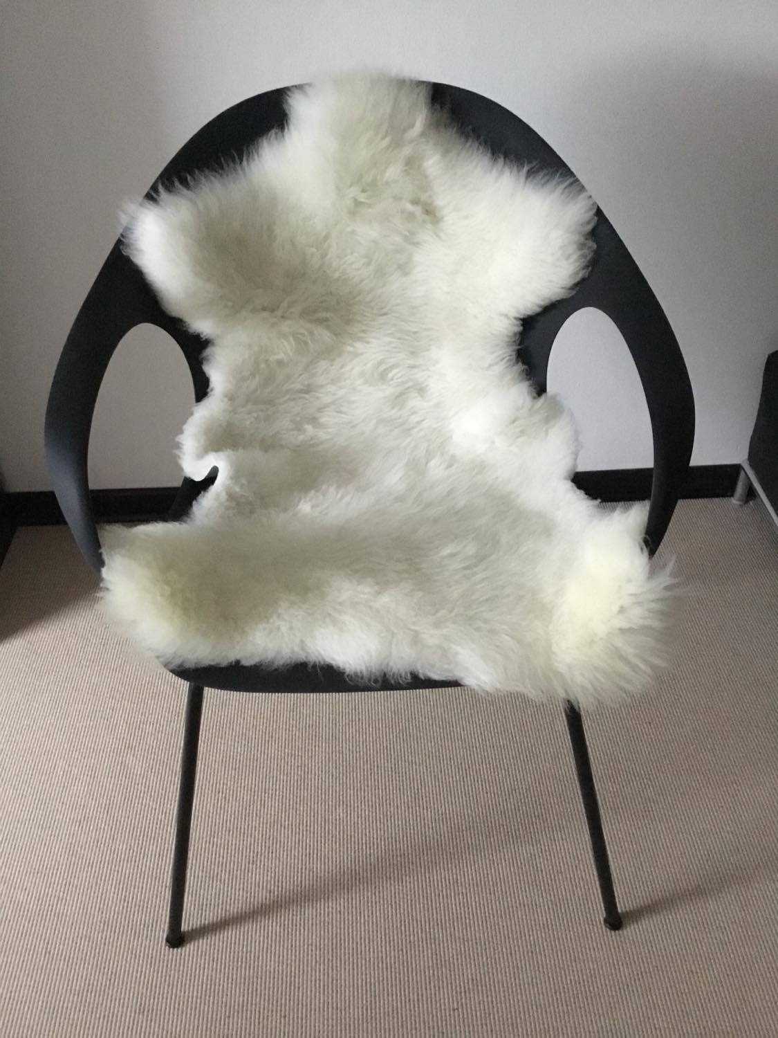 Topsy Farms' white lambskin on a black modern arm chair