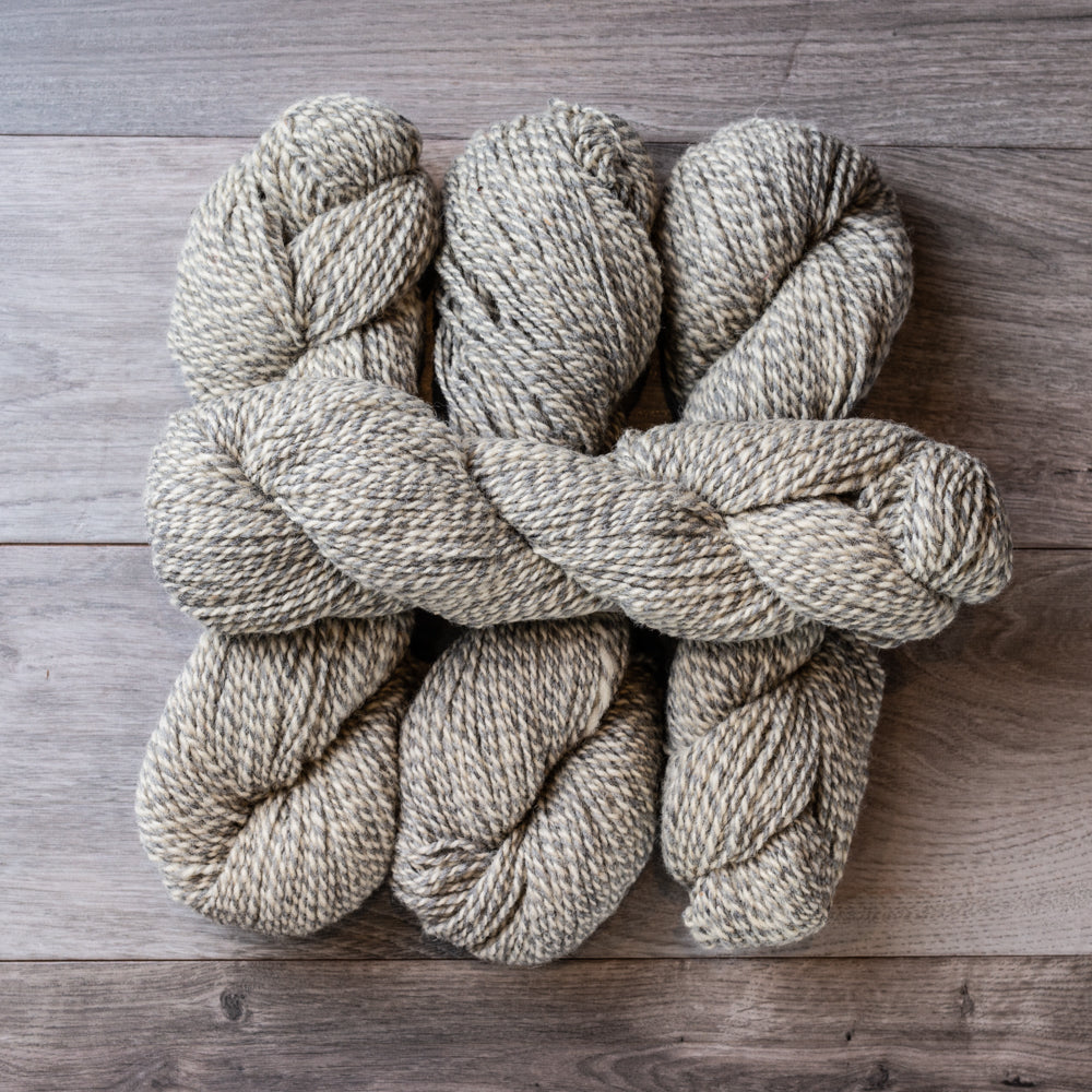 Grey and White skeins of yarn.