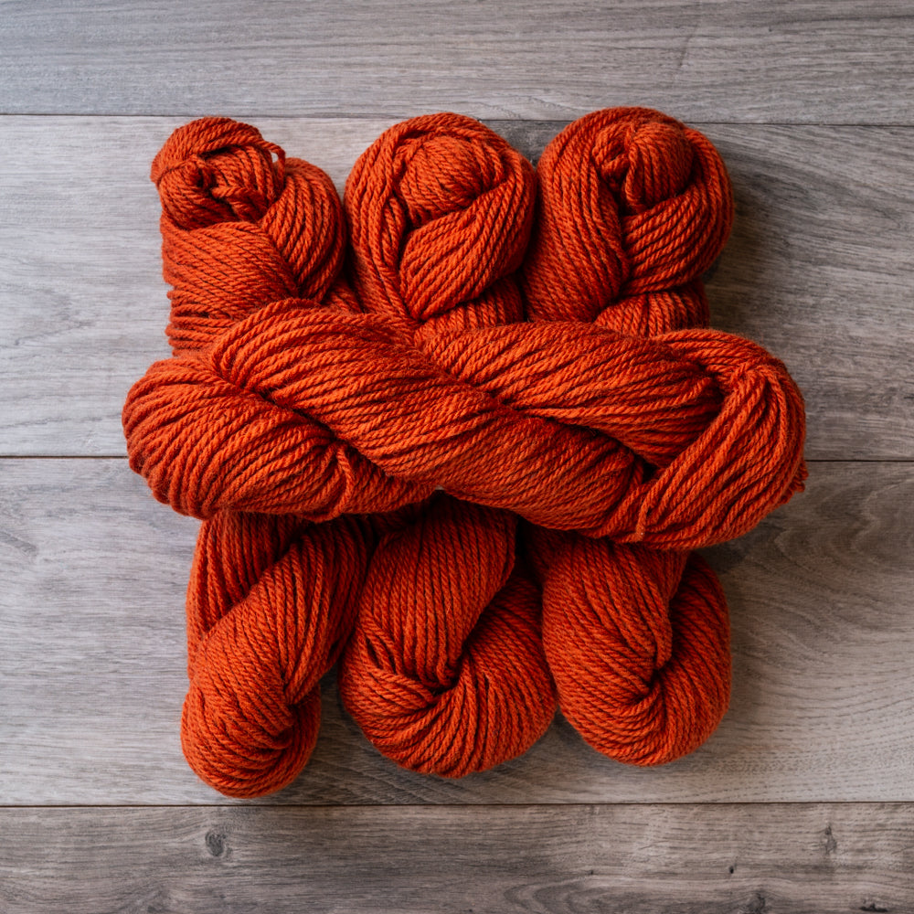 Burnt Orange skeins of Topsy Farms wool yarn.