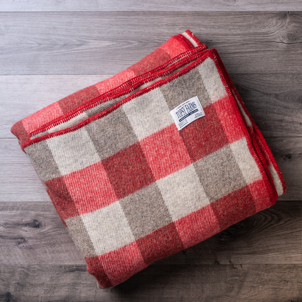 Grey and red queen blanket made of natural wool.