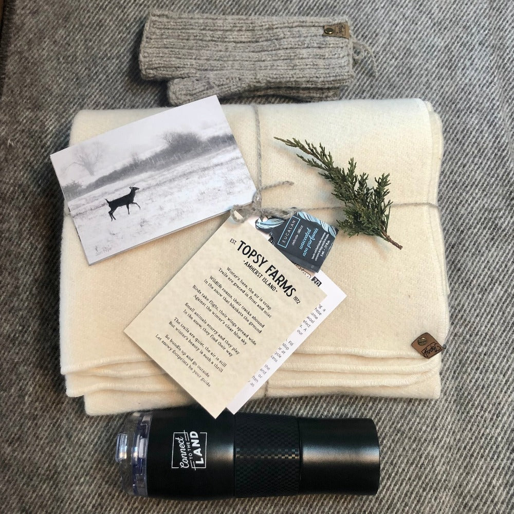 Topsy Farms' winter trails box, featuring wool wrap, travel mug, and fingerless gloves